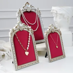 Detail of vintage-style red velvet jewelry display stands with ornate gold frames