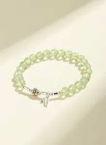 Close-up view of a prehnite beaded bracelet with silver flower and leaf charms