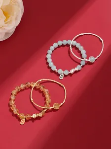 Detailed macro view of crystal beaded bracelets with lucky charms on festive red background