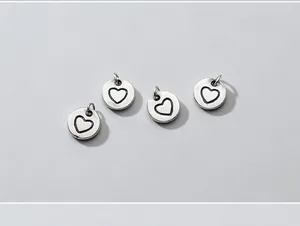 Detail view of S925 silver vintage heart stamped round charm pendant for DIY bracelet making.