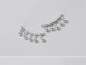 Detailed macro view of silver 6mm ball pendants hanging from curved tube DIY beads