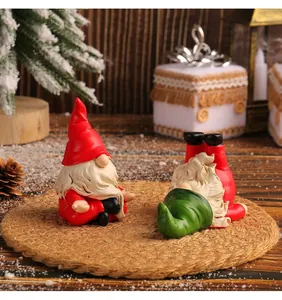 Close-up of Christmas gnomes in playful yoga poses on a cozy festive wooden surface.