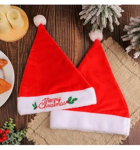 Close-up of velvet Christmas hats with "Merry Christmas" embroidery and holiday props.