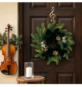 Detailed view of a dark green Christmas wreath with reindeer and golden berries decoration