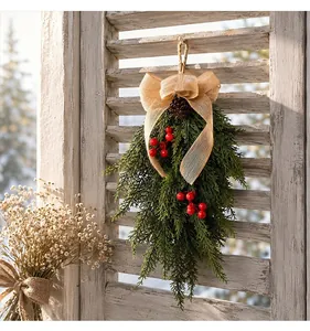 Detailed view of a rustic Christmas swag with evergreen branches and red berries.