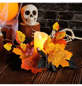 Close-up of Halloween candle wreath with autumn maple leaves and glowing LED candle.