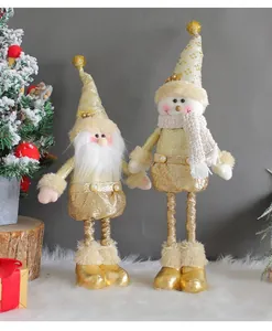 Nahaufnahme von goldenen Weihnachtsmann- und Schneemann-Standpuppen auf weißem Fell
