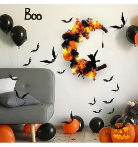 Dettaglio della ghirlanda a luna di Halloween con gatto nero e fiori arancioni vivaci