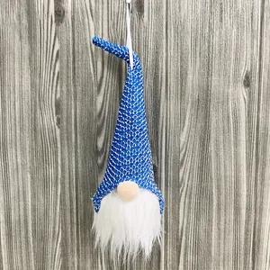Primer plano de un gnomo de Navidad de lentejuelas azules con barba blanca en madera