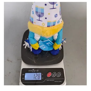 Close-up view of a Hanukkah gnome plush doll weighing 128g on a digital kitchen scale