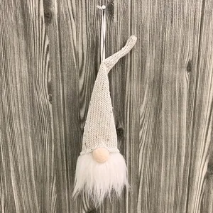 Vista detallada de un gnomo de Navidad de punto blanco con lentejuelas y barba suave.