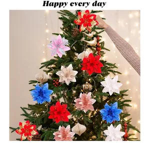Détail de fleurs de Noël colorées à trois épaisseurs suspendues sur un sapin décoré