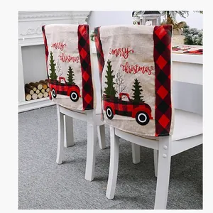 Detail view of burlap Christmas chair covers featuring red truck and plaid patterns