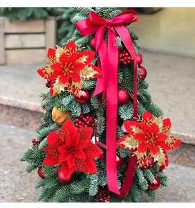 Gros plan d'une fleur de poinsettia rouge à trois couches avec des détails dorés brillants