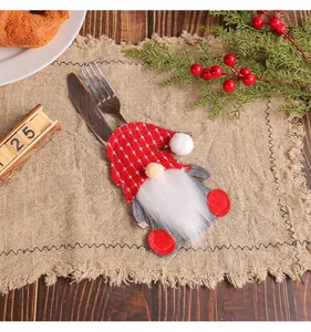 Cute Christmas gnome felt cutlery holder with knife and fork on a rustic burlap mat