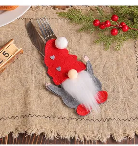 Detailed view of a Christmas gnome felt cutlery bag on a beige linen table runner