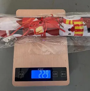 Détail de la bannière de Noël à carreaux pesée sur une balance affichant 229g