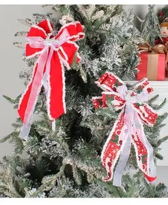 Detailansicht handgefertigter roter Weihnachtsbaumschleifen mit silbernem Rentier
