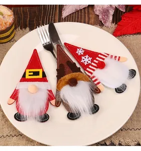 Close-up detail of festive gnome Christmas cutlery holders on a white ceramic plate