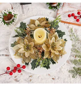 Overhead detail of a Christmas candle wreath with golden glitter poinsettias and greenery