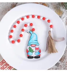 Christmas gnome ornament with red and white wooden beads on white plate