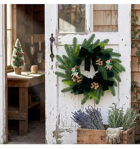 Festive dark green Christmas wreath with reindeer and velvet bow on a wooden door