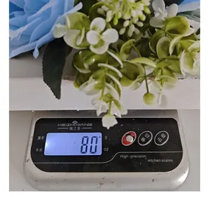 Close-up detail of artificial blue rose wreath weight measurement showing 80 grams on a scale