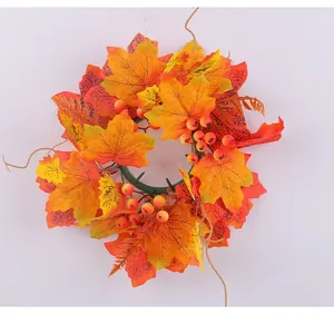 Detail of autumn candle wreath with vibrant maple leaves and red berries