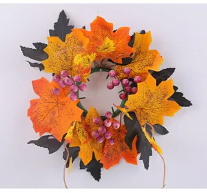 Detail of autumn candle ring with orange maple leaves and purple berries decoration