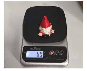 Detailed view of sitting Christmas gnome figurine weighing 80g on a digital kitchen scale