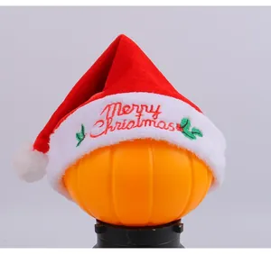 Detailed view of 'Merry Christmas' embroidery on a plush red and white velvet Santa hat
