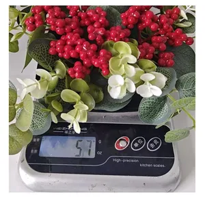 Decoración de eucalipto artificial y bayas rojas pesada en báscula digital de precisión