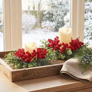 Elegantes coronas de velas de eucalipto de Navidad con bayas rojas en bandeja