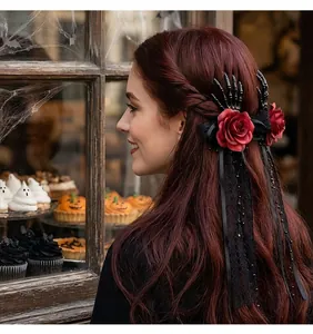 Detailed view of Halloween skeleton hand hair clip with red roses and black lace ribbons