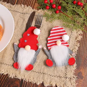 Pair of festive Christmas gnome felt cutlery holders for holiday tabletop decoration.