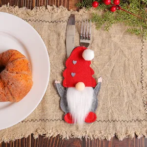 Festive Christmas gnome felt cutlery holder sleeve on linen mat for table decor