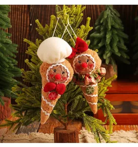 Handmade gingerbread man cone Christmas ornaments hanging on a decorative pine tree