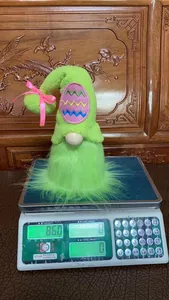 Detailansicht einer grünen Osterwichtel-Plüschpuppe auf einer Digitalwaage mit 86 g Gewicht