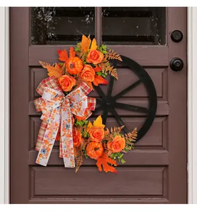 Rustic wagon wheel autumn wreath featuring orange roses, pumpkins, and a decorative bow.