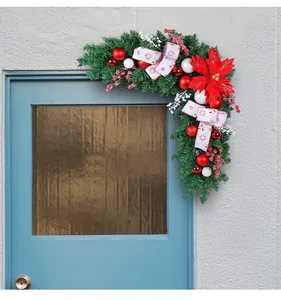 Festive Christmas door corner swag with red poinsettia and baubles on a blue door