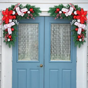 Festive Christmas door corner swags with red poinsettias, berries and white ribbons