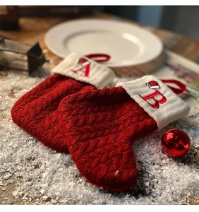 Primer plano de calcetines de Navidad de punto rojo con letras bordadas A y B