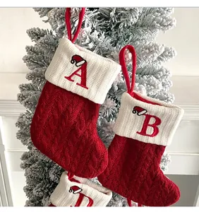 Primer plano de calcetines de Navidad de punto rojo con bordado de letras en puños blancos