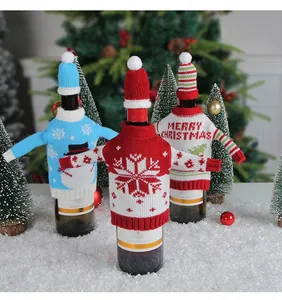 Drei festliche gestrickte Weihnachts-Weinflaschenhüllen mit Hüten und Schneemustern