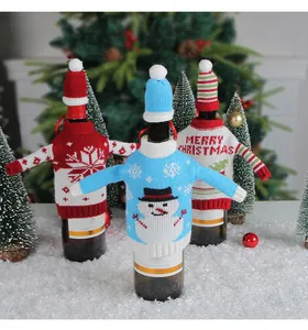 Nahaufnahme von drei gestrickten Weihnachts-Weinflaschenhüllen mit festlichen Schneemännern.