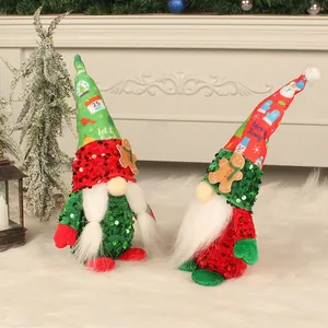 Festive pair of Christmas gnomes with sequined hats and gingerbread man decor on white fur rug.