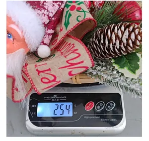 Detail of a Santa Claus Christmas wreath showing a weight of 254g on a digital scale.