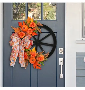 Autumn wagon wheel wreath with pumpkins and roses hanging on a blue front door.