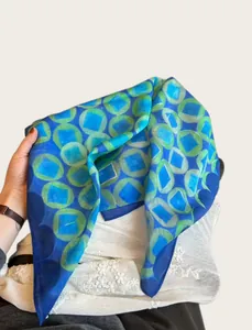 Detail view of lightweight blue and green geometric pattern printed silk scarf wrap