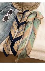 Detailed shot of vintage paisley thin silk scarves in gold and mint green colors.